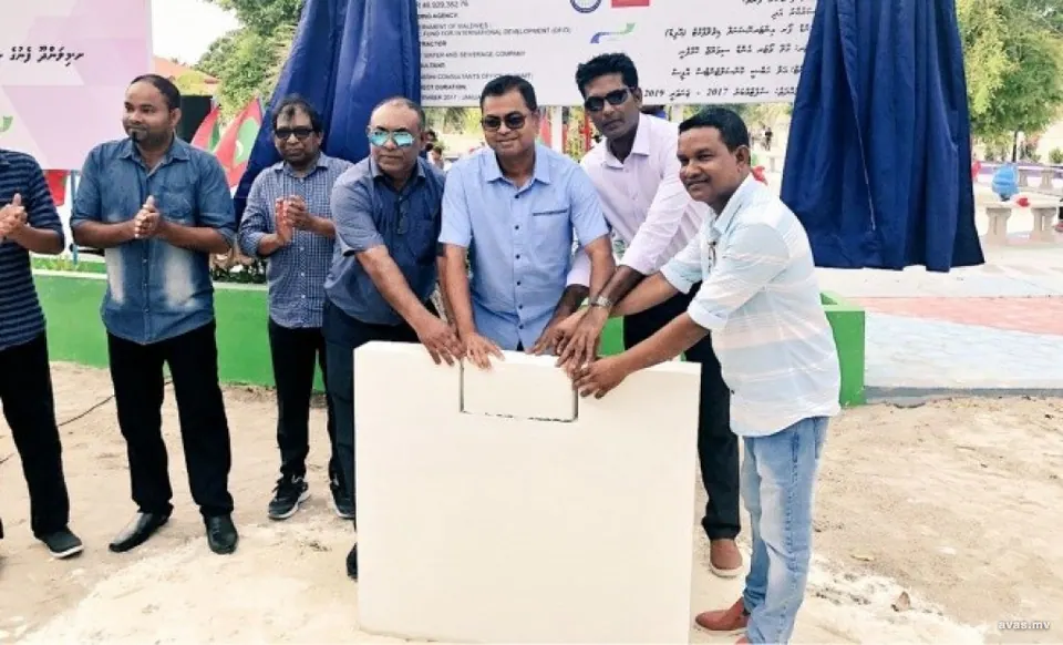 Officials at the launch ceremony for Milandhoo's water supply works, 10 March 2018, with the project signboard behind them